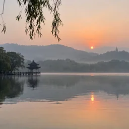 晨雾中的湖面与远处亭阁